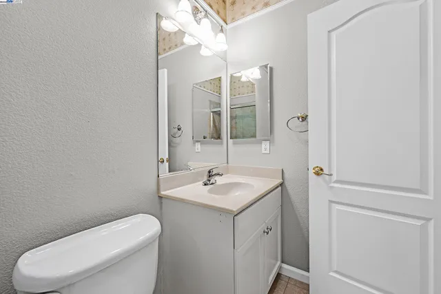 a bathroom with a granite countertop toilet sink and mirror