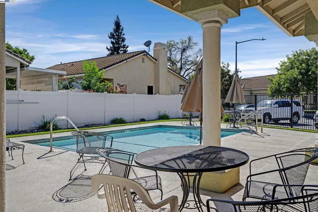 a backyard of a house with table and chairs