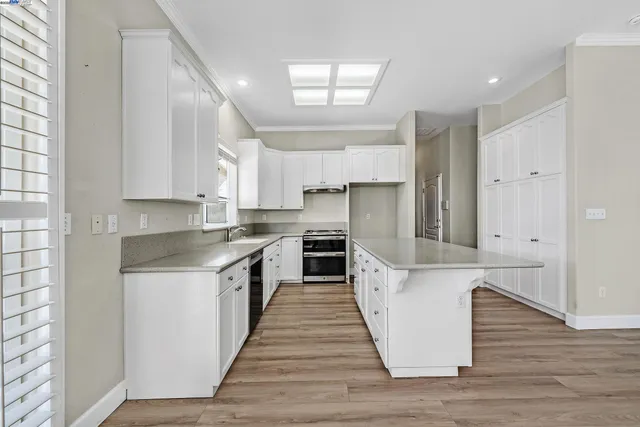 a large kitchen with stainless steel appliances granite countertop a stove and a sink