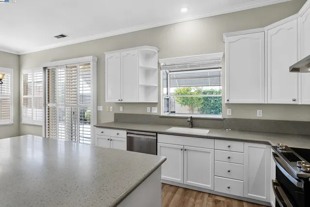 a kitchen with stainless steel appliances granite countertop a sink a stove and cabinets