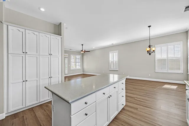 a kitchen with granite countertop white cabinets and a wooden floor