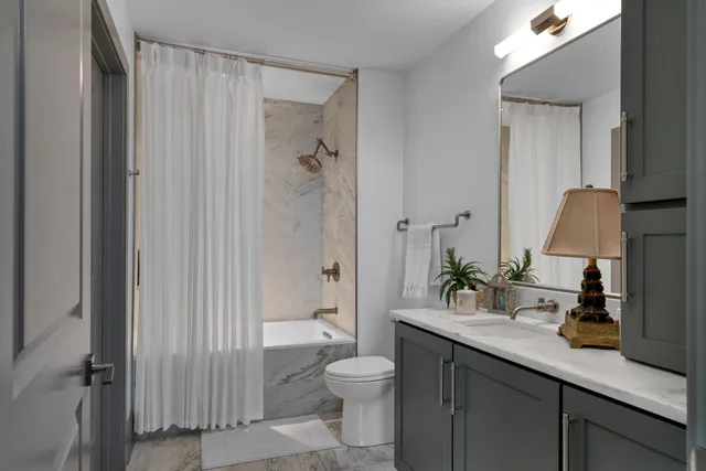 a bathroom with a granite countertop sink toilet and shower