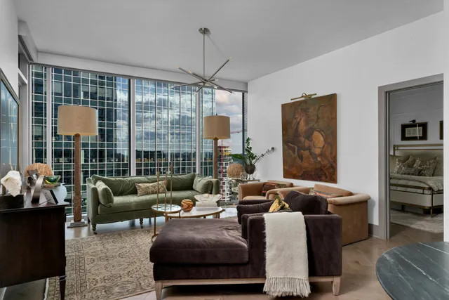 a living room with furniture a lamp and a large window