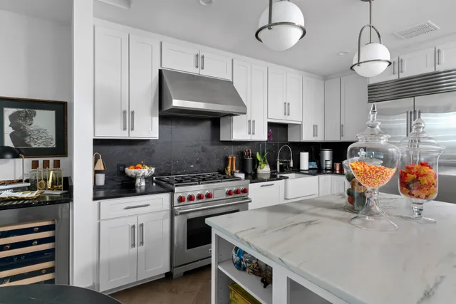 a kitchen with stainless steel appliances a stove a sink and a refrigerator