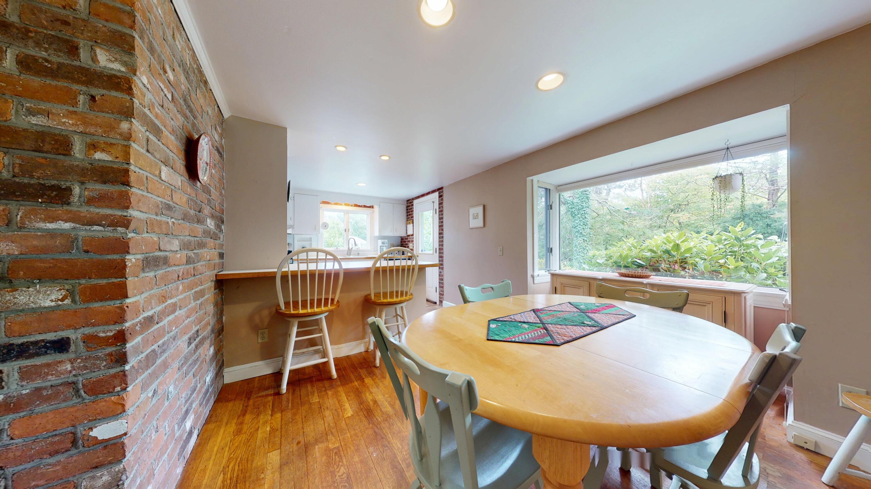 55 Monument View Road East Dennis, MA 02660 - Photo 16 of 40 a dining room with furniture and a floor to ceiling window