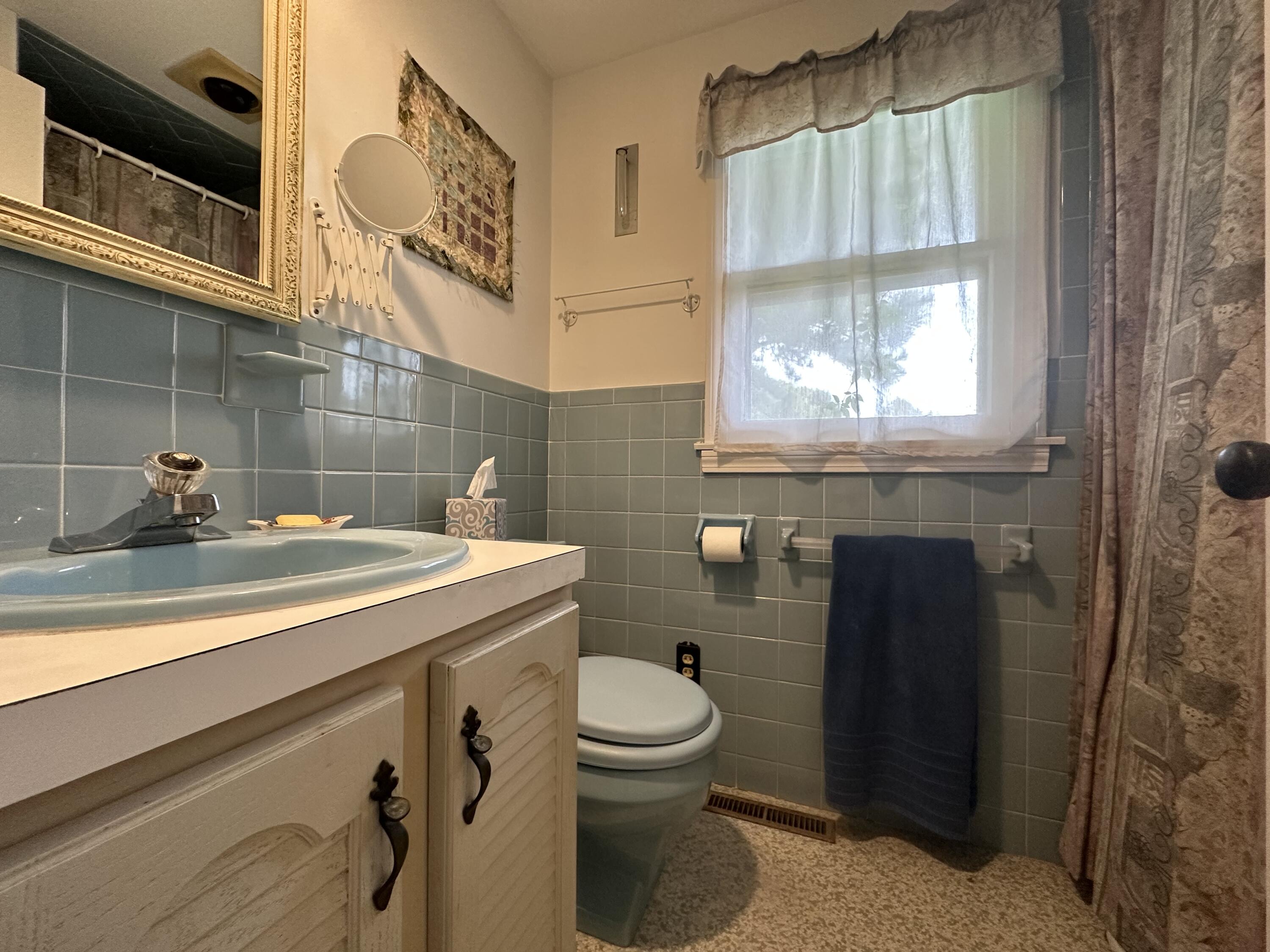 55 Monument View Road East Dennis, MA 02660 - Photo 23 of 40 a bathroom with a sink a toilet and a shower curtain