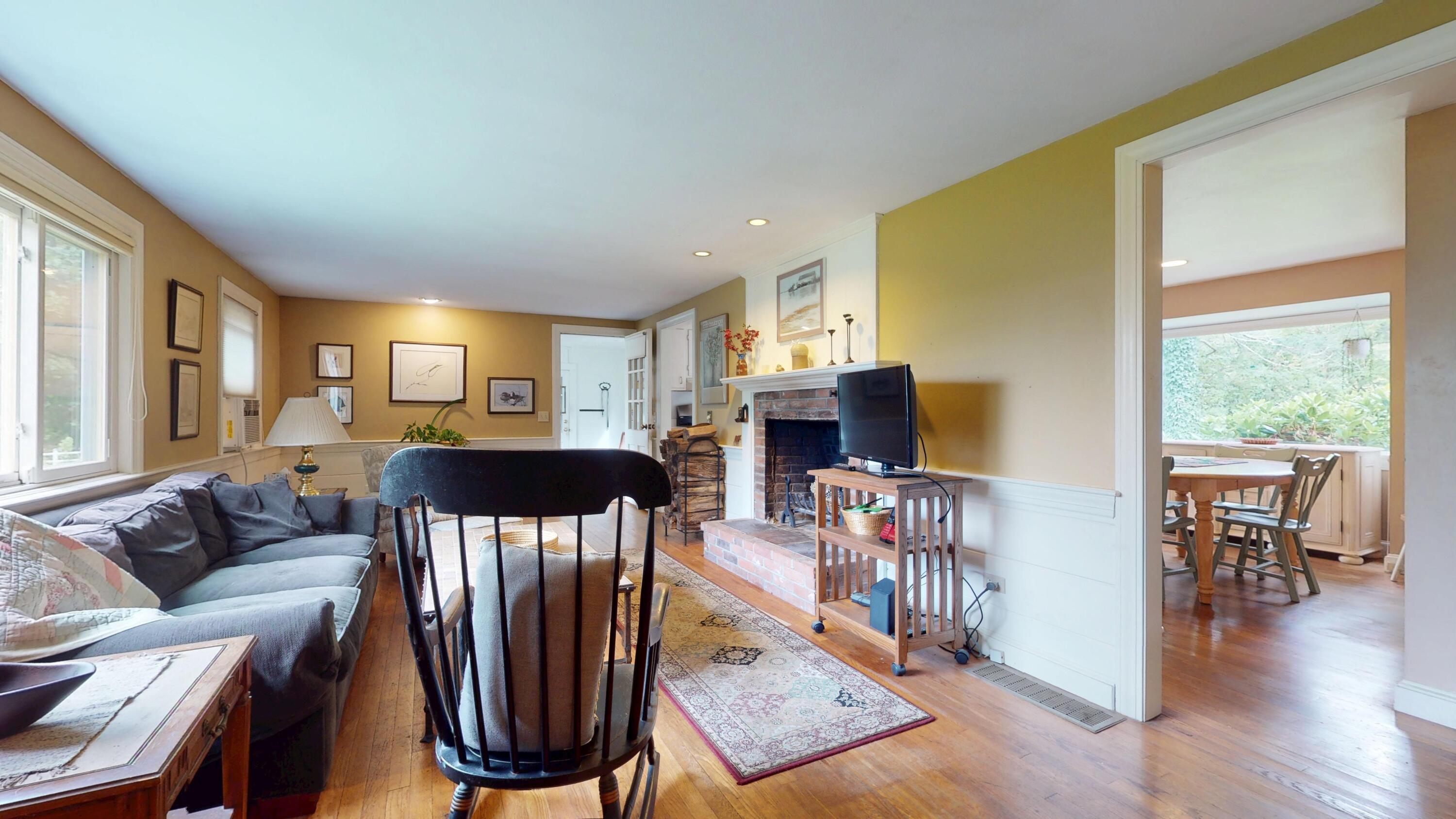 55 Monument View Road East Dennis, MA 02660 - Photo 9 of 40 a living room with furniture a fireplace and a flat screen tv