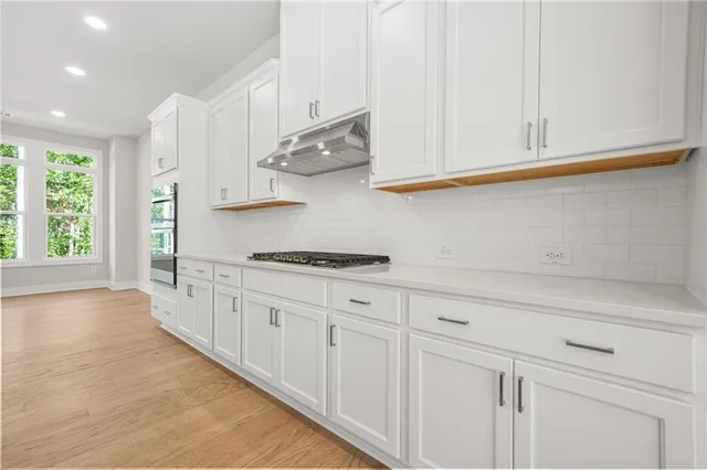 a kitchen with granite countertop white cabinets and white appliances