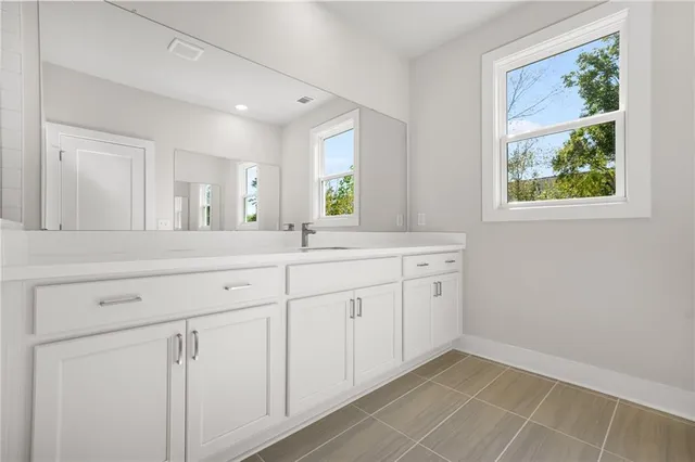 a spacious bathroom with 2 sink and a mirror