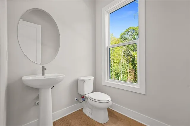 a bathroom with a toilet a sink and a mirror