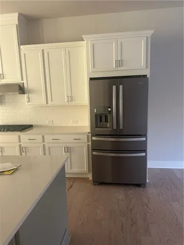 a kitchen with white cabinets and a refrigerator