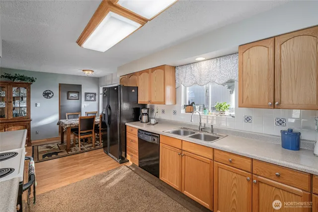 a kitchen with stainless steel appliances sink stove refrigerator and cabinets