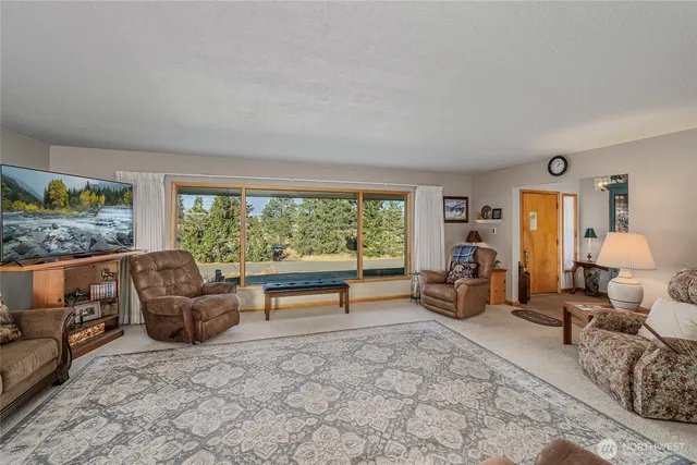 a living room with furniture and a floor to ceiling window