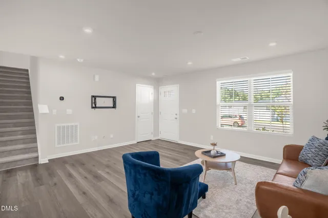 a living room with furniture and a wooden floor