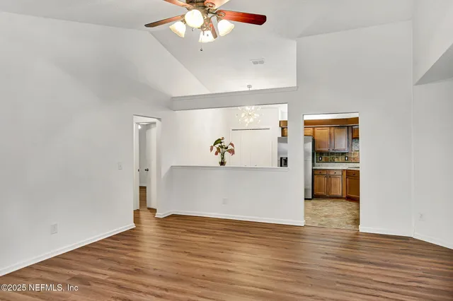 a view of house in front of a big yard with large trees