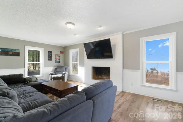 a living room with furniture a fireplace and a flat screen tv