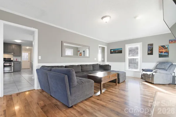 a living room with furniture and a wooden floor