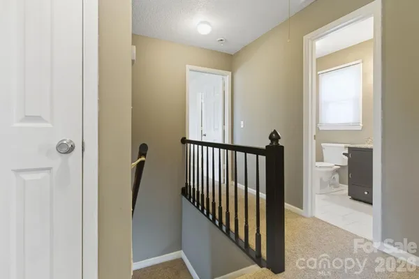 a view of a hallway with a door and a living room