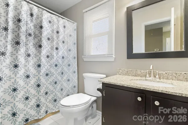 a bathroom with a granite countertop sink and a toilet