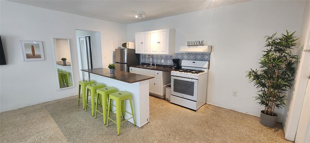 7725 Harding Avenue, Unit 4 Miami Beach, FL 33141 - Photo 2 of 6 a kitchen with kitchen island a stove a sink and a refrigerator