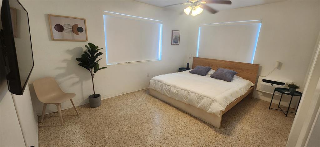 7725 Harding Avenue, Unit 4 Miami Beach, FL 33141 - Photo 4 of 6 a bedroom with a bed and a chandelier