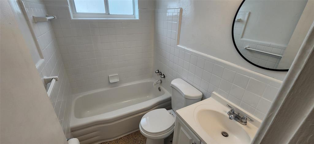 7725 Harding Avenue, Unit 4 Miami Beach, FL 33141 - Photo 5 of 6 a white toilet sitting next to a bath tub