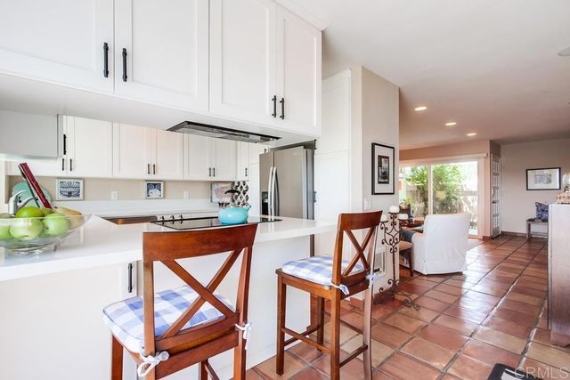 a kitchen with stainless steel appliances kitchen island granite countertop a table chairs in it and a wooden floors