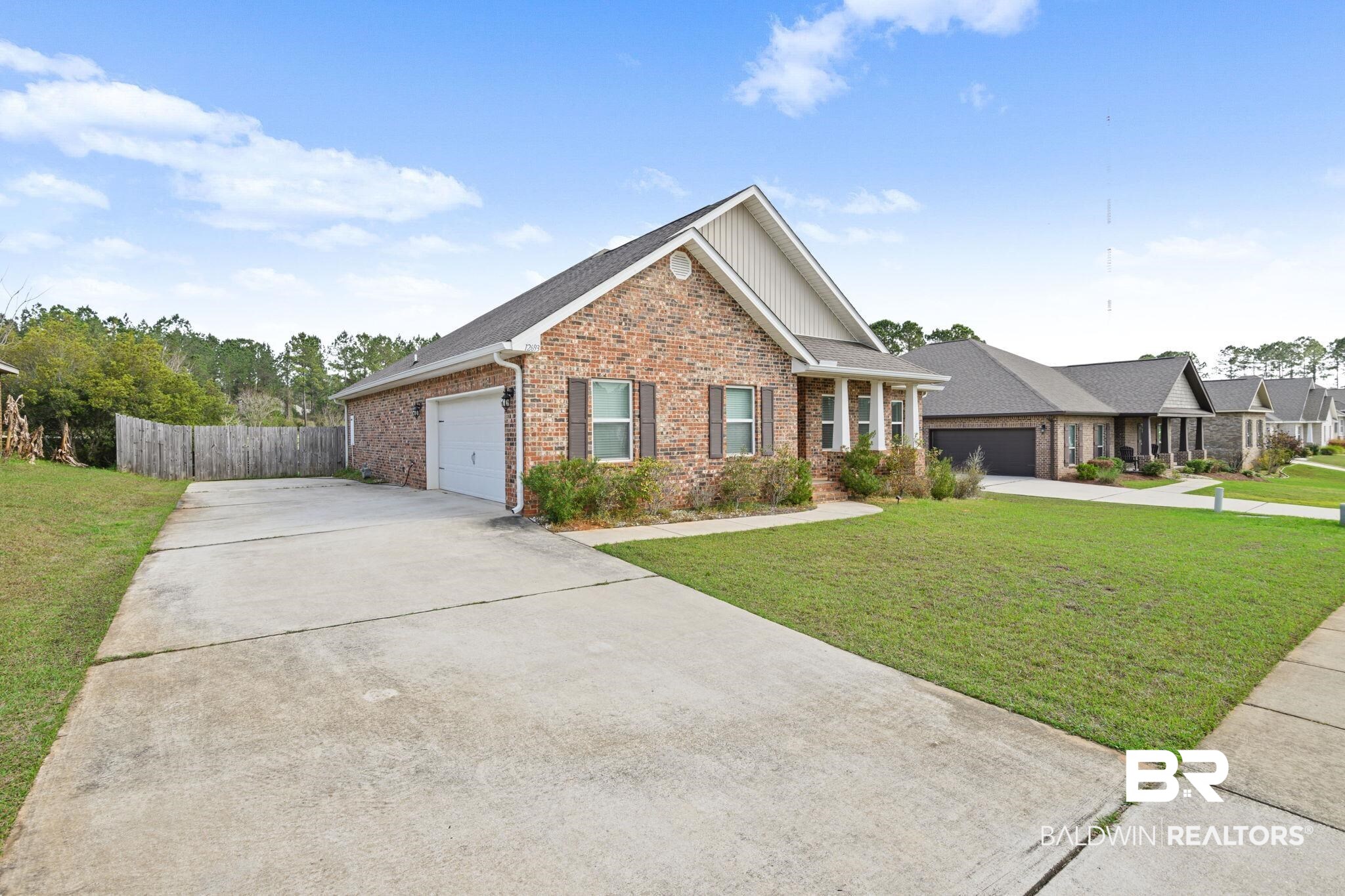 12693 Waxwing Avenue Daphne, AL 36527 - Photo 4 of 43 View of front of home featuring concrete driveway, a garage, brick siding, and board and batten siding