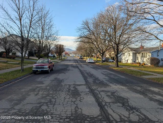 a view of a street with a cars parked on the road