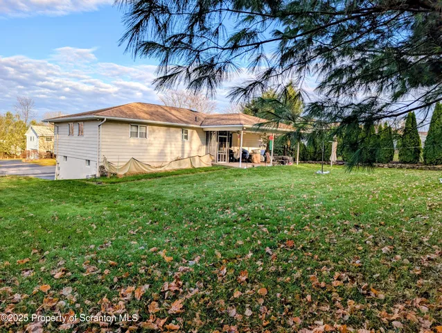 a view of a house with a big yard and large trees