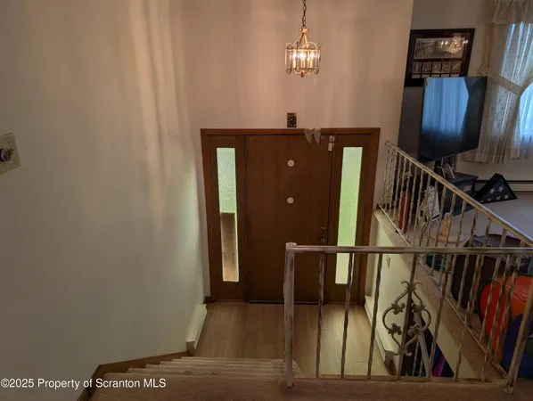 a view of a hallway with wooden floor and stairs