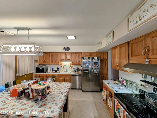 a kitchen with stainless steel appliances kitchen island granite countertop a refrigerator and a stove