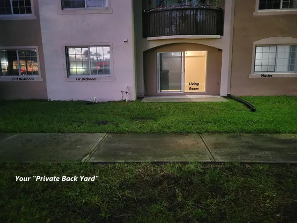 an aerial view of a house with a yard and tennis court