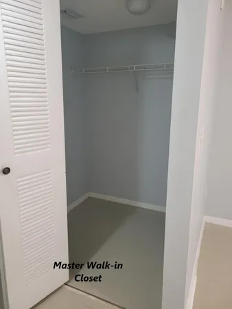 a view of a hallway with wooden floor and a living room
