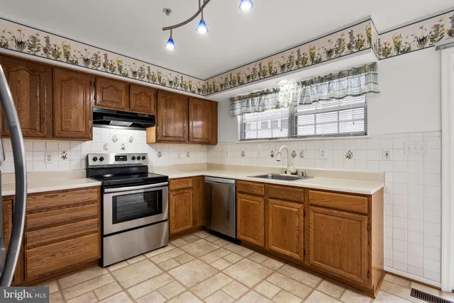 a kitchen with granite countertop a sink stainless steel appliances and cabinets