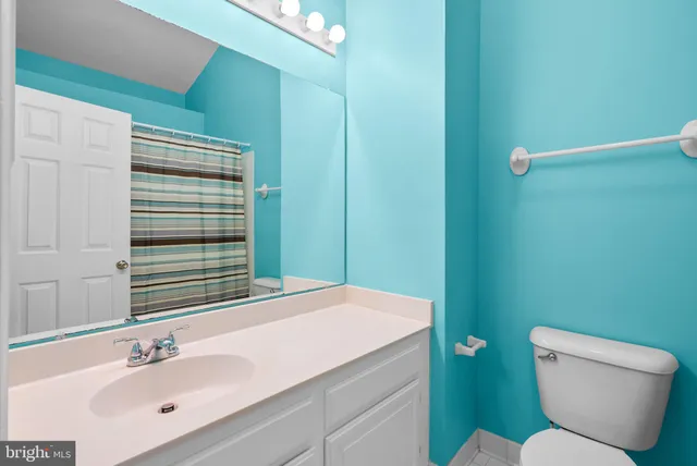 a bathroom with a toilet a sink and mirror