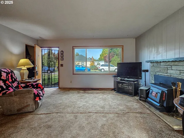 a living room with furniture a window and a flat screen computer