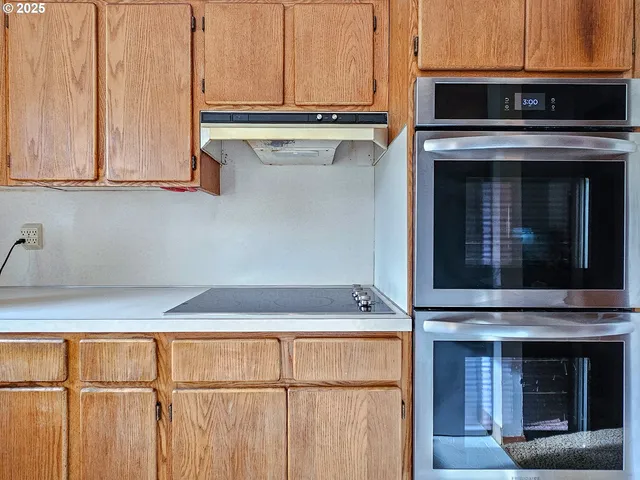 a kitchen with granite countertop cabinets stainless steel appliances and a counter space