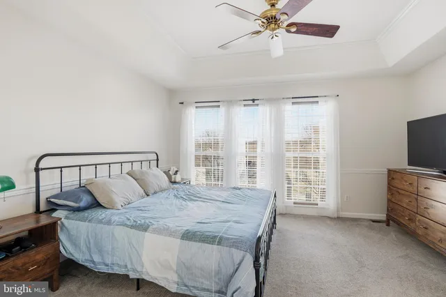 a bedroom with a bed and a flat tv screen on dresser