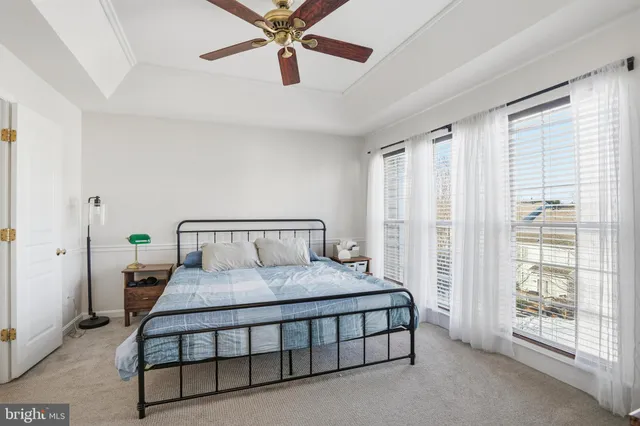 a bedroom with a bed a lamp and a large window