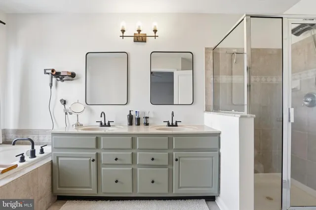 a bathroom with double vanity sinks and a mirror