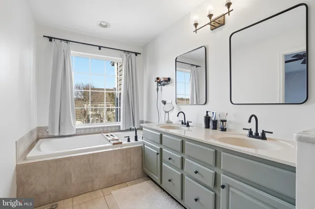 a bathroom with a tub sink and mirror