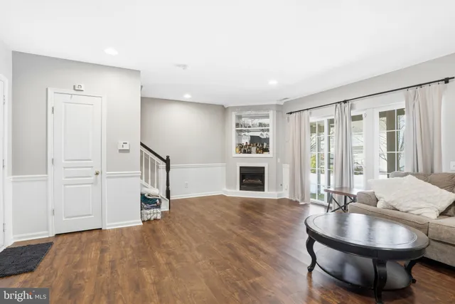 a living room with furniture a fireplace and a floor to ceiling window