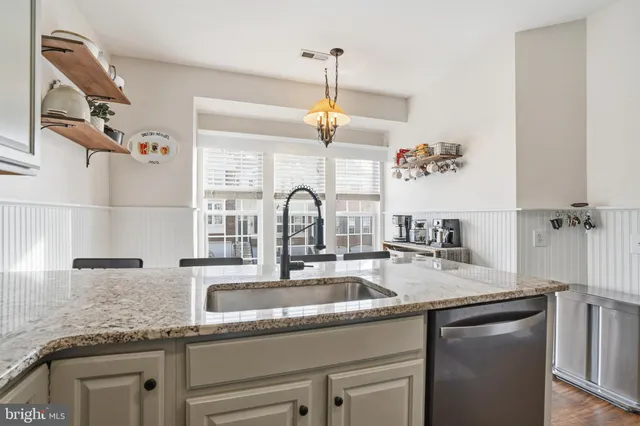 a kitchen with a granite countertop sink a window and appliances