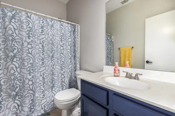 a bathroom with a granite countertop toilet and a sink