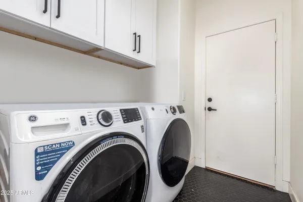 a view of washer and dryer with kitchen in the background