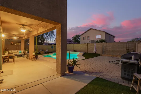 a view of a patio with a table and chairs under an umbrella with wooden fence