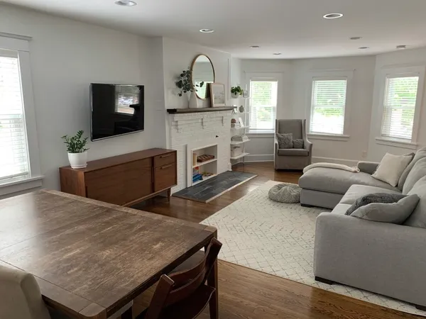a living room with furniture fireplace and window