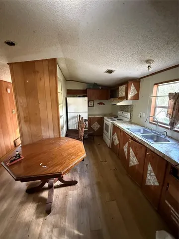 a room with stainless steel appliances kitchen island granite countertop a sink dishwasher stove and cabinets