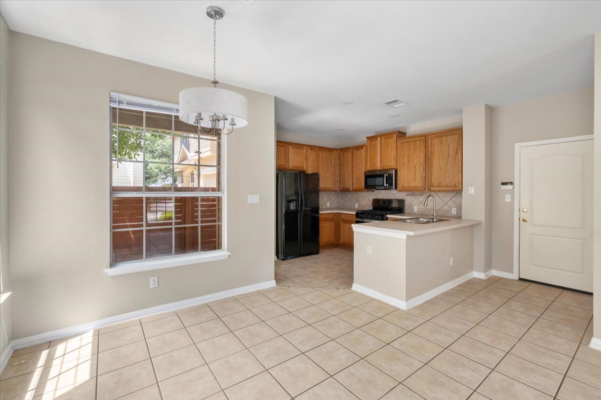11000 Anderson Mill Road, Unit 11 Austin, TX 78750 - Photo 6 of 34 A well-lit kitchen with natural wood cabinetry and a functional island for casual dining.